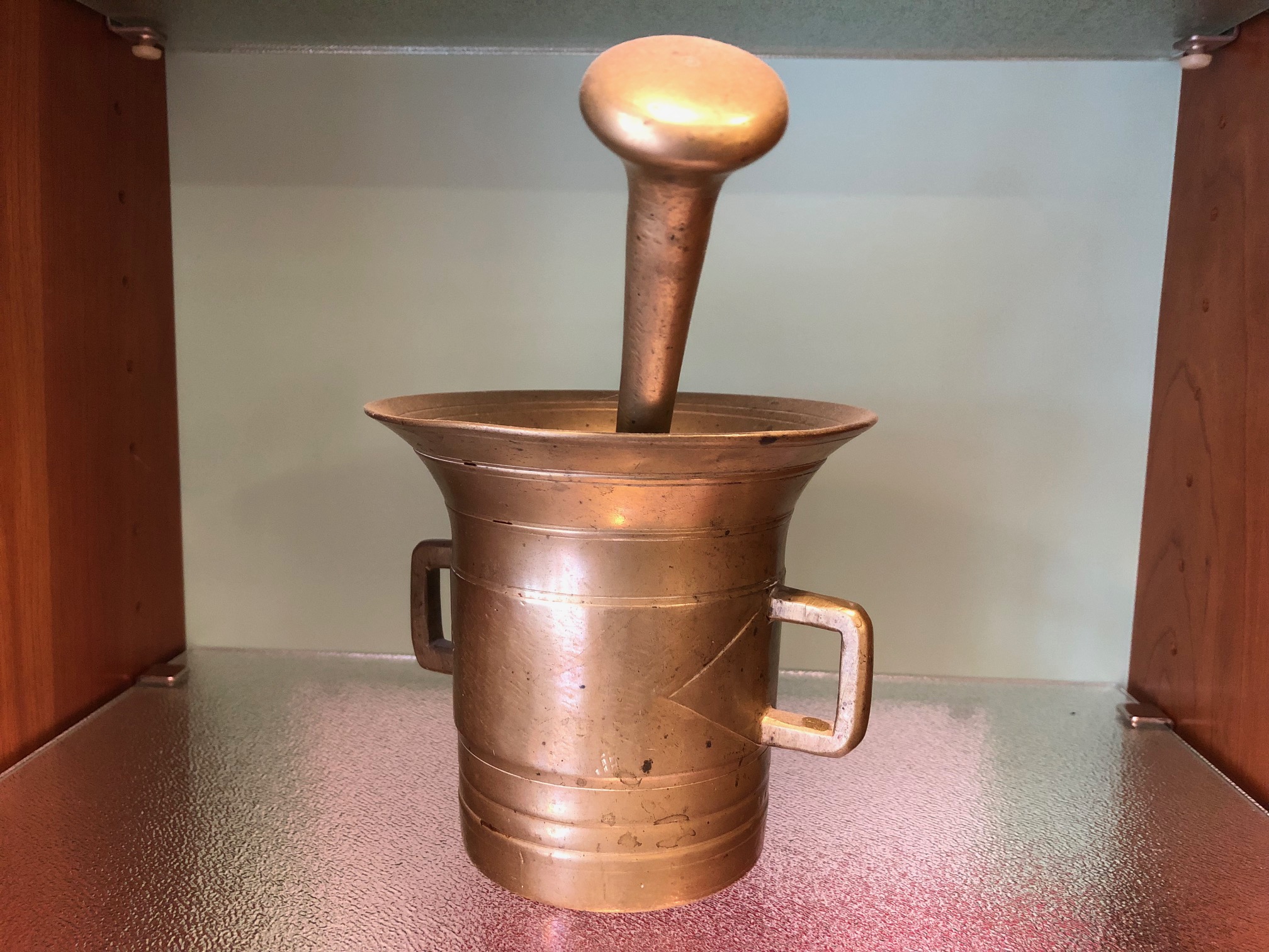 Das Bild zeigt einen historischen Messing-Mörser der Plantagen Apotheke.